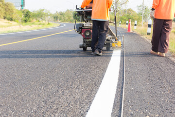 Machine eject and worker on road and traffic sign painting