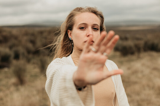 Woman showing stop gesture in field