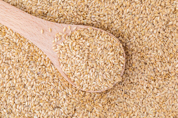 Flax seeds background, close up, flax seeds in a wooden spoon, linen seeds white, organic food