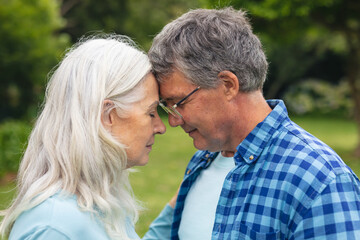 Obraz premium Romantic caucasian senior couple with face to face standing in backyard