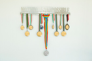 Medaglie d'oro e d'argento appese con su scritto 