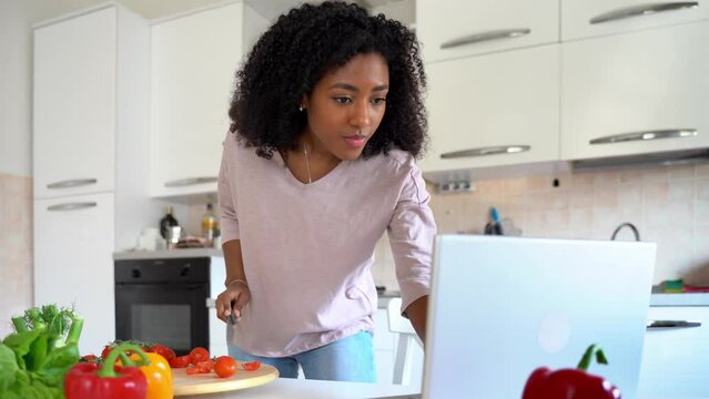 Video about one black woman watching cooking tutorial online at home