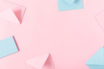Romantic composition. Pink and blue envelopes on pink background. Flat lay, top view, copy space 