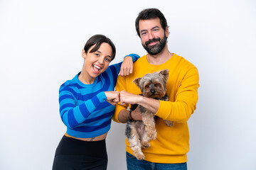 Young hispanic woman holding a dog isolated on white background bumping fists