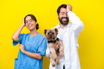Young veterinarian couple with dog isolated on yellow background has realized something and intending the solution