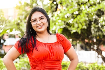 Portrait of hispanic curvy woman outdoors looking at camera.