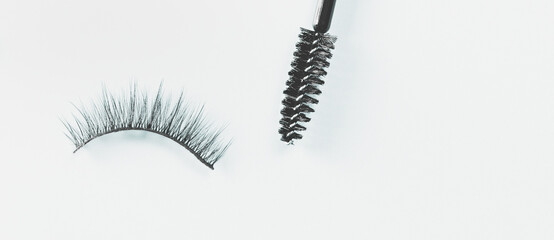 Overhead eyelashes and brushes on blue background. Makeup of female eyes. Eyelash extension. Piece care. Banner.