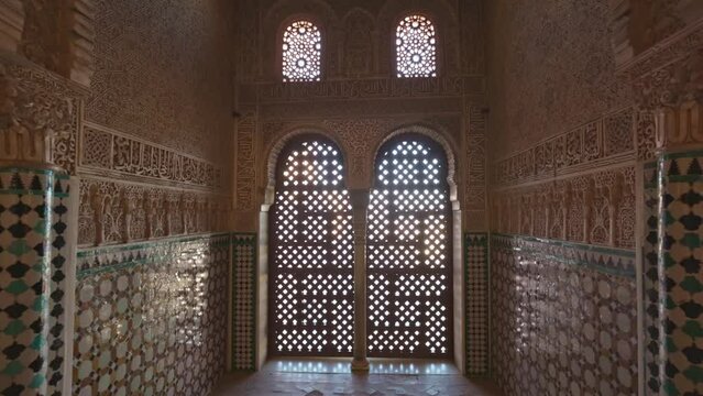 Magnificent moorish interior in Alhambra palace, Granada. Camera moves to arches of the window between the walls with Moorish ornaments. Gimbal shot, 4K
