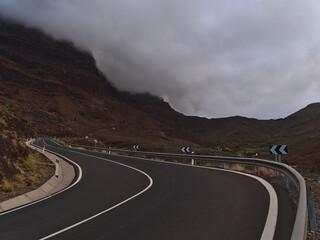View of remote country road GC-200 in the west of Gran Canaria, Canary Islands, Spain near village La Aldea de San Nicolas surrounded by mountains.