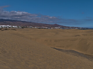 Beautiful view over the famous sand dunes Dunas de Maspalomas in the south of island Gran, Canaria, Canary Islands, Spain on sunny day with hotel.