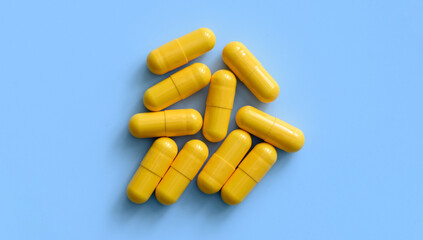 Yellow medicine pills on a blue background