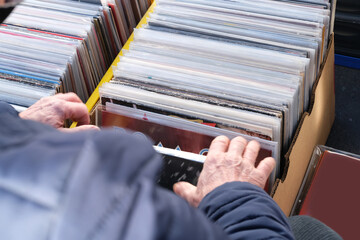 flea market flip in the city, man choosing vinyl records, antiques, old furniture, tables, used...