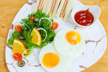 breakfast in a marble plate There are sandwiches, fried eggs, salad.