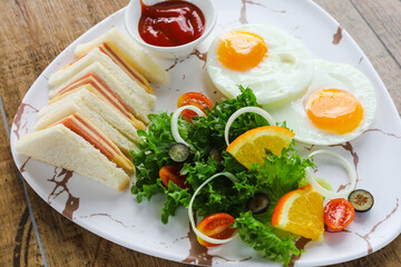 breakfast in a marble plate There are sandwiches, fried eggs, salad.