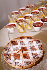 crostata di pasticceria con monoporzioni di dolci mignon assortite 