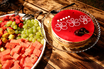 Torte colorate e frutta assortita disposti in un tavolo e pronti per essere serviti 