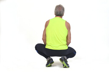 back view of a senior man with sportswear squatting on white background