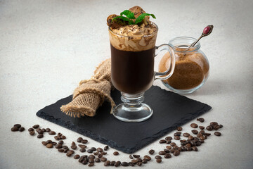 Dalgona coffee with jar of cookies on light background