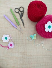 Top view. Red and pink yarn. Various knitting needles. Creative knitting hobby background with text space.