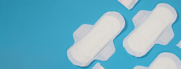 Woman sanitary napkins on blue background. Top view. Absorbent pads worn by women to absorb menstrual blood. Comfortable white sanitary napkins arranged on light blue paper. Represent Hygiene concept © gnepphoto