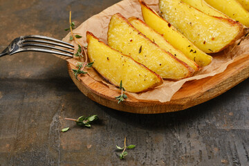 Fried potato wedges in a wooden plate. Potato wedges fries chips with thyme. Shallow depth of field
