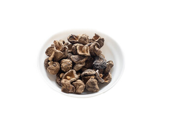 dried shiitake mushrooms in a plate on a white background