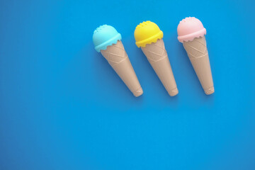 toy ice cream of different colors on a colored background 