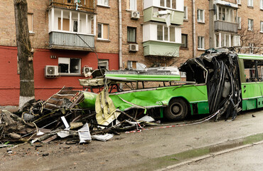 Obraz premium The trolleybus was destroyed on the street after Russian shelling. consequences of the war in Ukraine. broken transport.