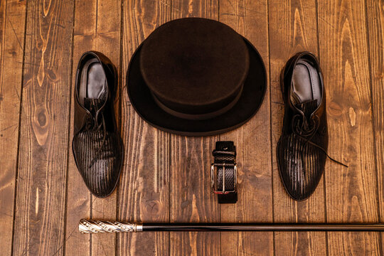 dettaglio di cappello , bastone scarpe e  cinta eleganti su tavolo in legno 