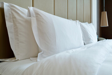 Fototapeta na wymiar White pillows and duvet on a bed