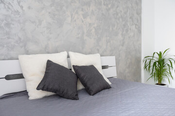 bed with gray linens in white interior