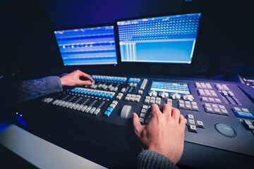 Mesa de control de iluminación. Manos de cerca usando faders de mesa de iluminación. Control de...