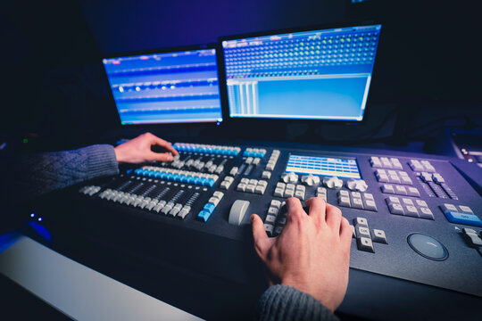 Mesa de control de iluminaci&oacute;n. Manos de cerca usando faders de mesa de iluminaci&oacute;n. Control de realizaci&oacute;n. Estudio de televisi&oacute;n. Producci&oacute;n de televisi&oacute;n.