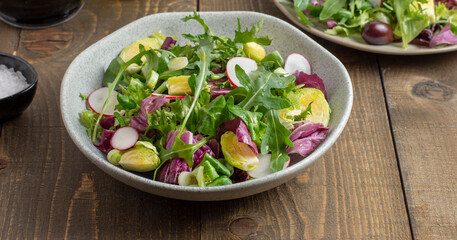 Vitamin salad with lettuce, spring onions, brussels sprout, cabbage, arugula and radish. Close up