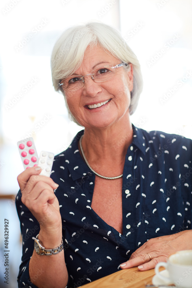 Poster Where my energy comes from. Cropped shot of a senior her holding up her medication while sitting in a cafe.