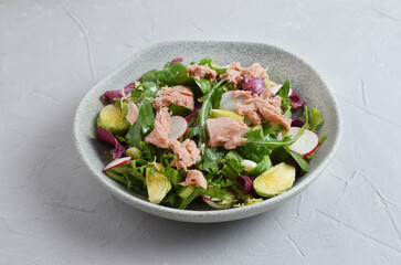 Tuna salad with lettuce, spring onions, brussels sprout, cabbage, arugula, radish and canned tuna. Vitamin salad. Close up.
