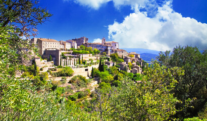 Fototapeta na wymiar Scenic panoramic view on medieval picturesque old french village on hill top, blue summer sky, fluffy clouds - Gordes, Provence, France