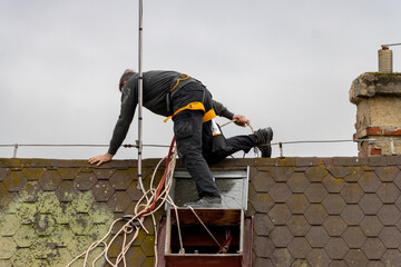A man works on a roof with a skylight