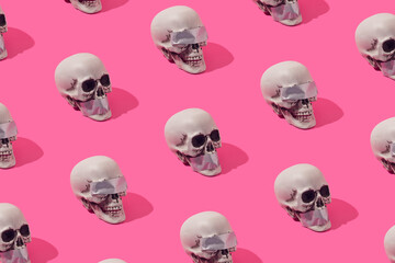 Human skulls with with duct tape over the eyes and mouth on a pink background. Truth and justice...
