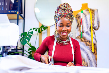 tanzanian woman with snake print turban over hear working in fashion house