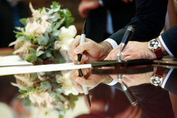 dettaglio firma di un documento importante su un foglio con la penna che riflette 