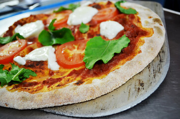 Caprese pizza on a pizza spade being served