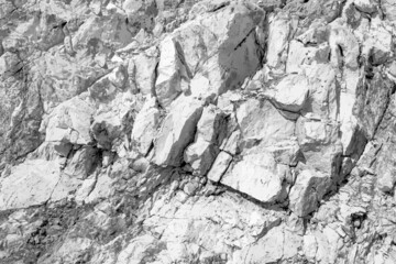 Grungy cragged bumpy pitted cavity stone facade, split layer gap.Ruined cracked shattered worn rough hiking canyon.Old ragged grunge steep marble cliff. Grand vintage crannied damaged impressive gorge