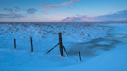 Morgenlicht über winterlicher Berglandschaft mit Fluss 