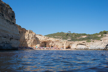 Fototapeta na wymiar Beautiful beach with tourists seen from a boat. Summer in Algarve, Portugal.