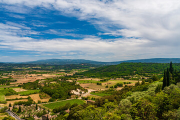 A small village with green fields under a cloudy sky in a sunny day in Avignon, Provence, France