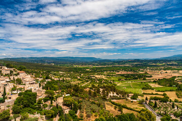 Fototapeta na wymiar A small village with green fields under a cloudy sky in a sunny day in Avignon, Provence, France