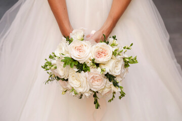 bellissimo dettaglio del bouquet di fiori di colori tenui  tenuto in mano da una sposa 