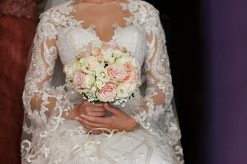 bellissimo dettaglio del bouquet di fiori di colori tenui  tenuto in mano da una sposa 