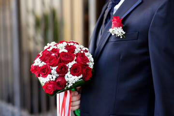 bouquet di fiori tenuto in mano da uno sposo in abito elegante